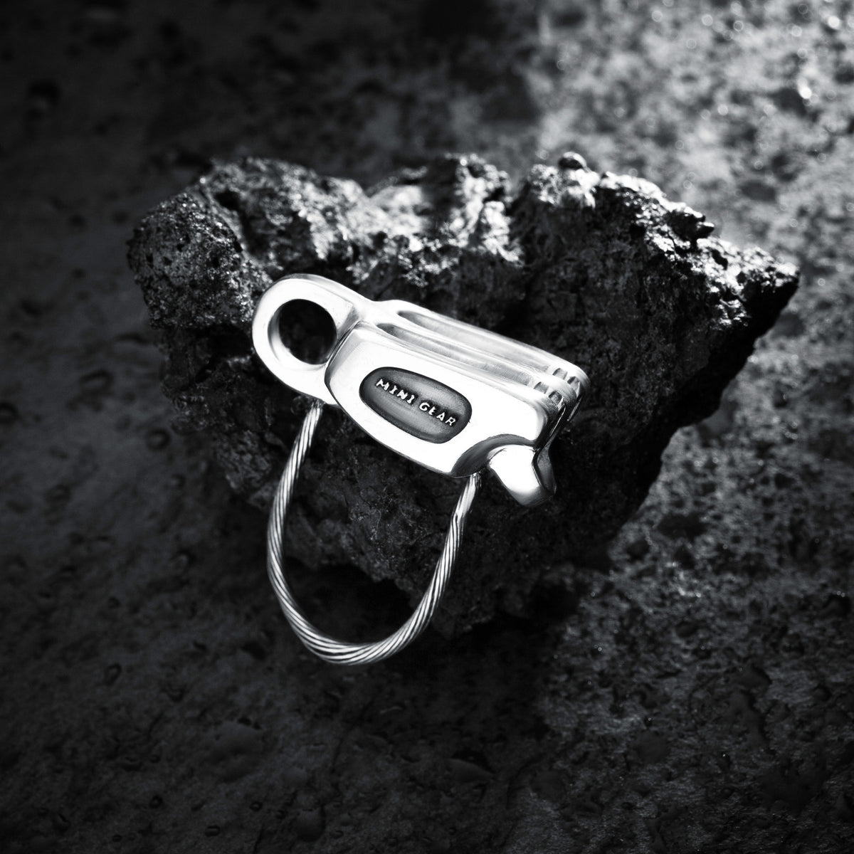 MiniGear Tube-Sicherungsgerät-Anhänger aus 925er Sterlingsilber auf dunklem Hintergrund