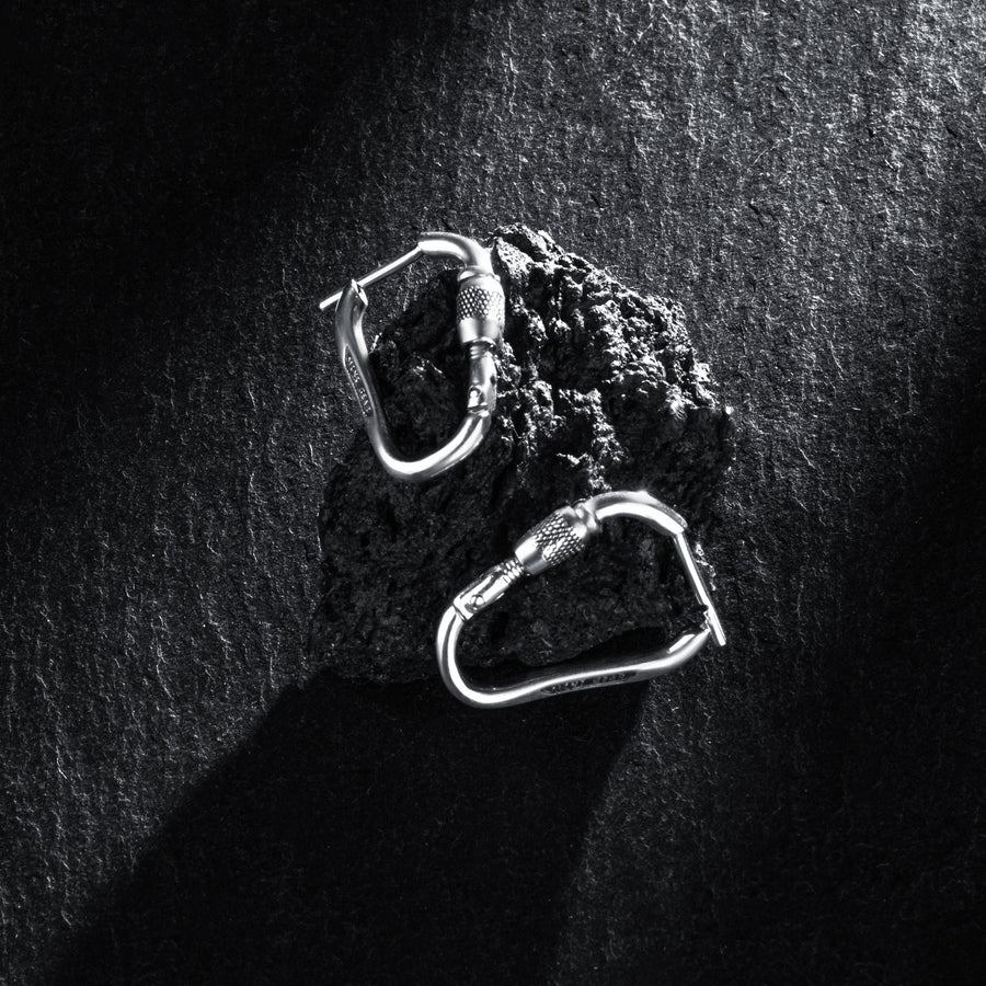 MiniGear Kletterkarabiner-Ohrringe aus 925er Sterlingsilber auf dunklem Hintergrund
